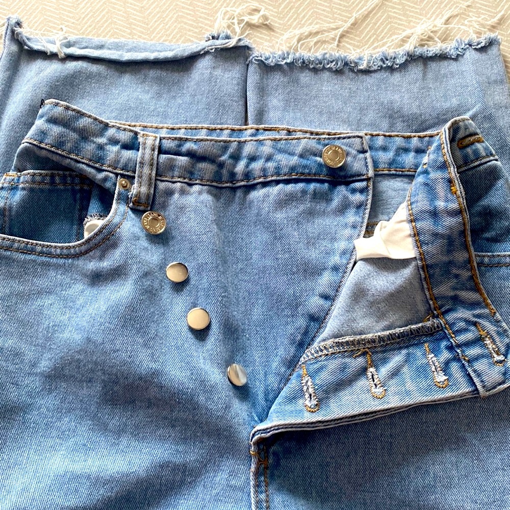 Fold over waist ripped straight jeans .
